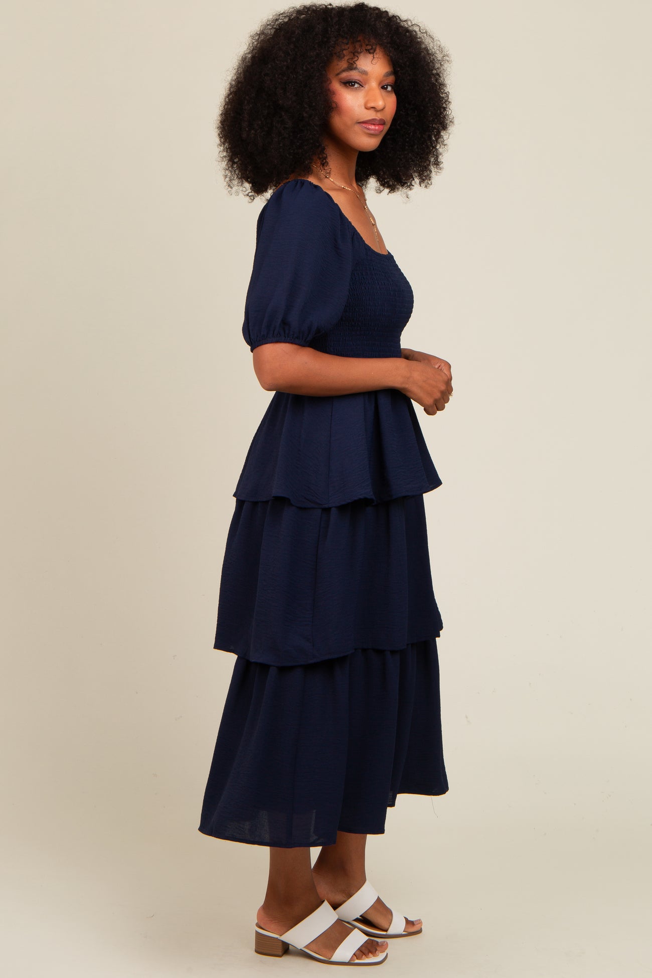 woman wearing a navy blue tiered maxi dress with puff sleeves and a smocked bodice