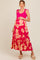 woman wearing a pink maternity maxi dress with floral print and ruffle hem, holding her baby bump
