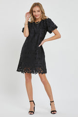 woman wearing a black lace short sleeve dress with a scalloped hem and a fitted silhouette