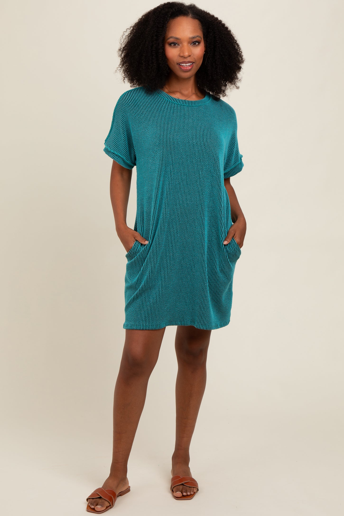 woman wearing a teal striped t-shirt dress with pockets and short sleeves