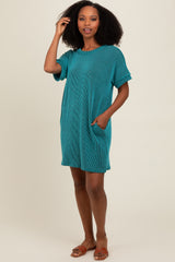 woman wearing a teal striped short sleeve loose dress with pockets