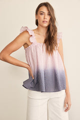 woman wearing a pink and navy ombre gingham top with ruffle straps and loose fit