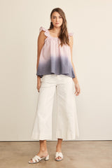 woman wearing a pink and navy blue ombre tank top with ruffle straps and white wide-leg culottes