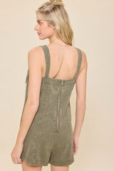 woman wearing a green denim overall romper with a zip back detail