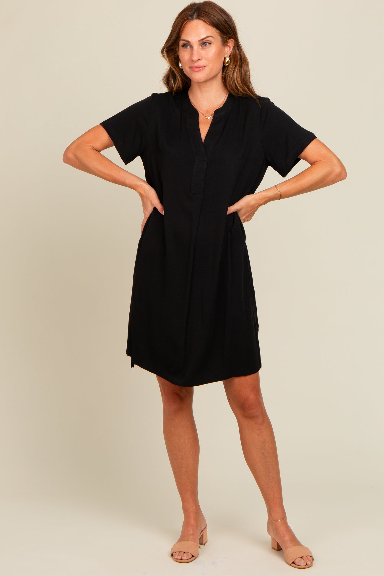 woman wearing a black short sleeve dress with a collared neckline and front placket