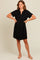woman wearing a black short sleeve dress with a collared neckline and front placket