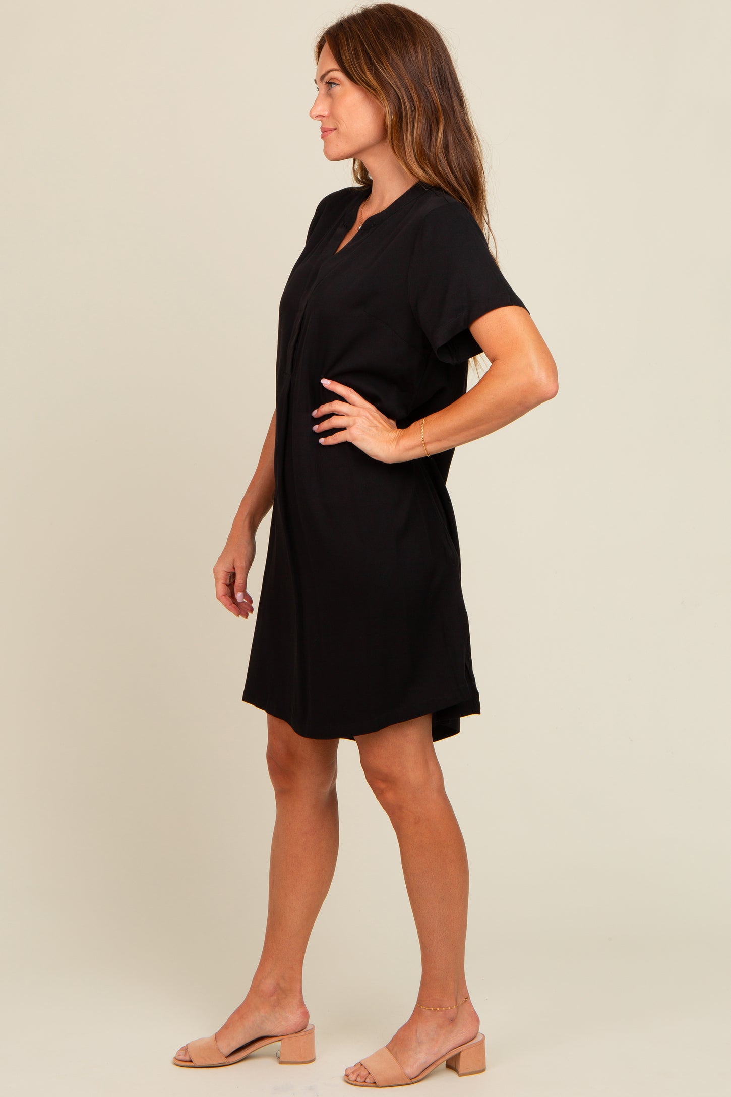 woman wearing a black short sleeve dress with a v-neckline and relaxed fit, styled with tan block-heeled sandals