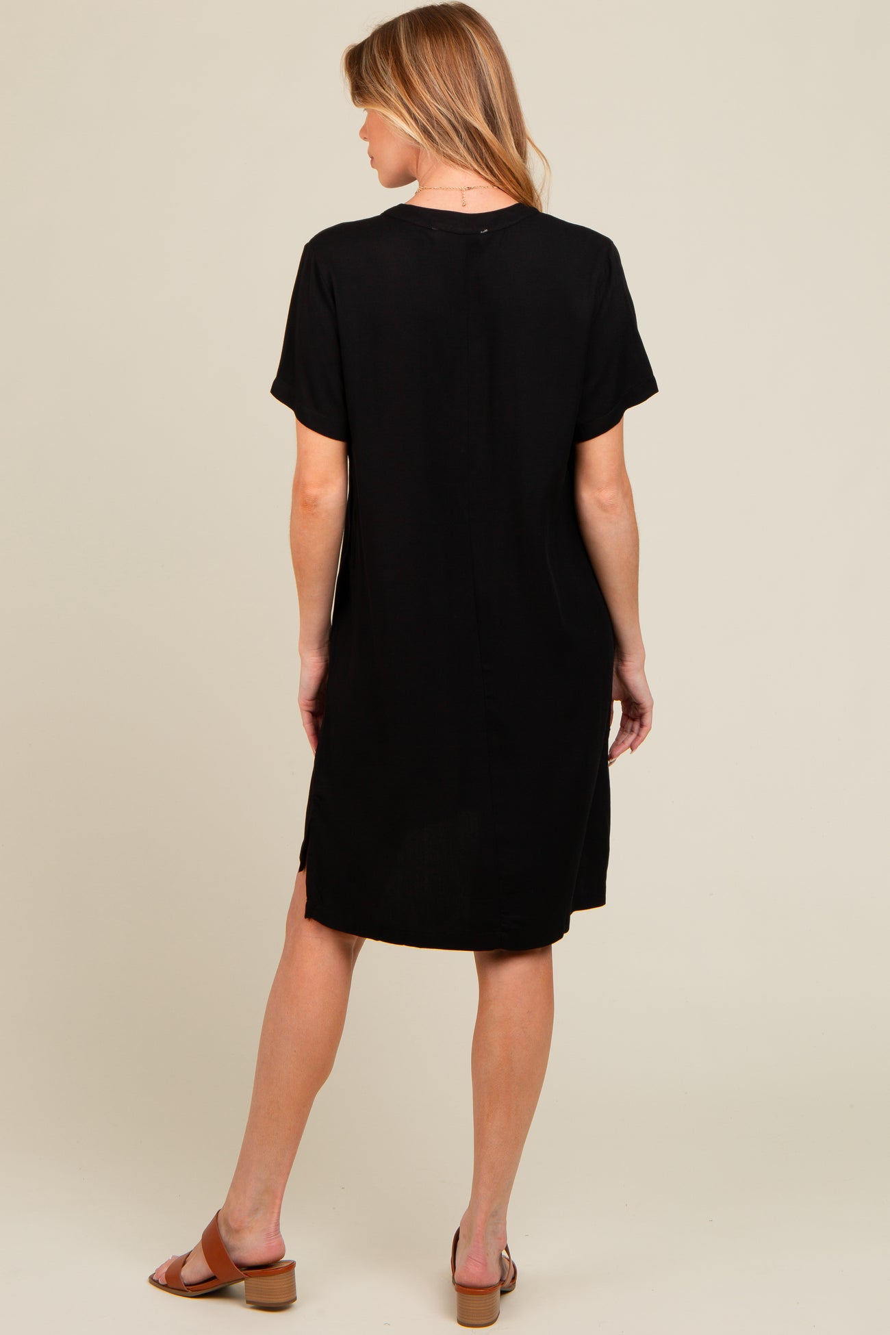 woman wearing a black short sleeve maternity dress, shown from the back
