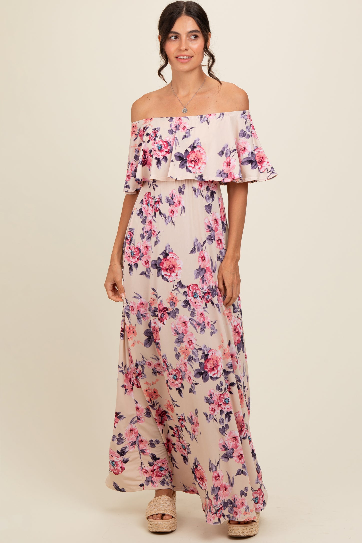 woman wearing a floral off-the-shoulder maxi dress with ruffle details and a flowing silhouette