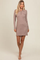 woman wearing a ribbed taupe long sleeve dress with a henley neckline and a chest pocket