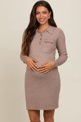 woman wearing a taupe ribbed maternity dress with a buttoned collar and pocket, gently cradling her baby bump