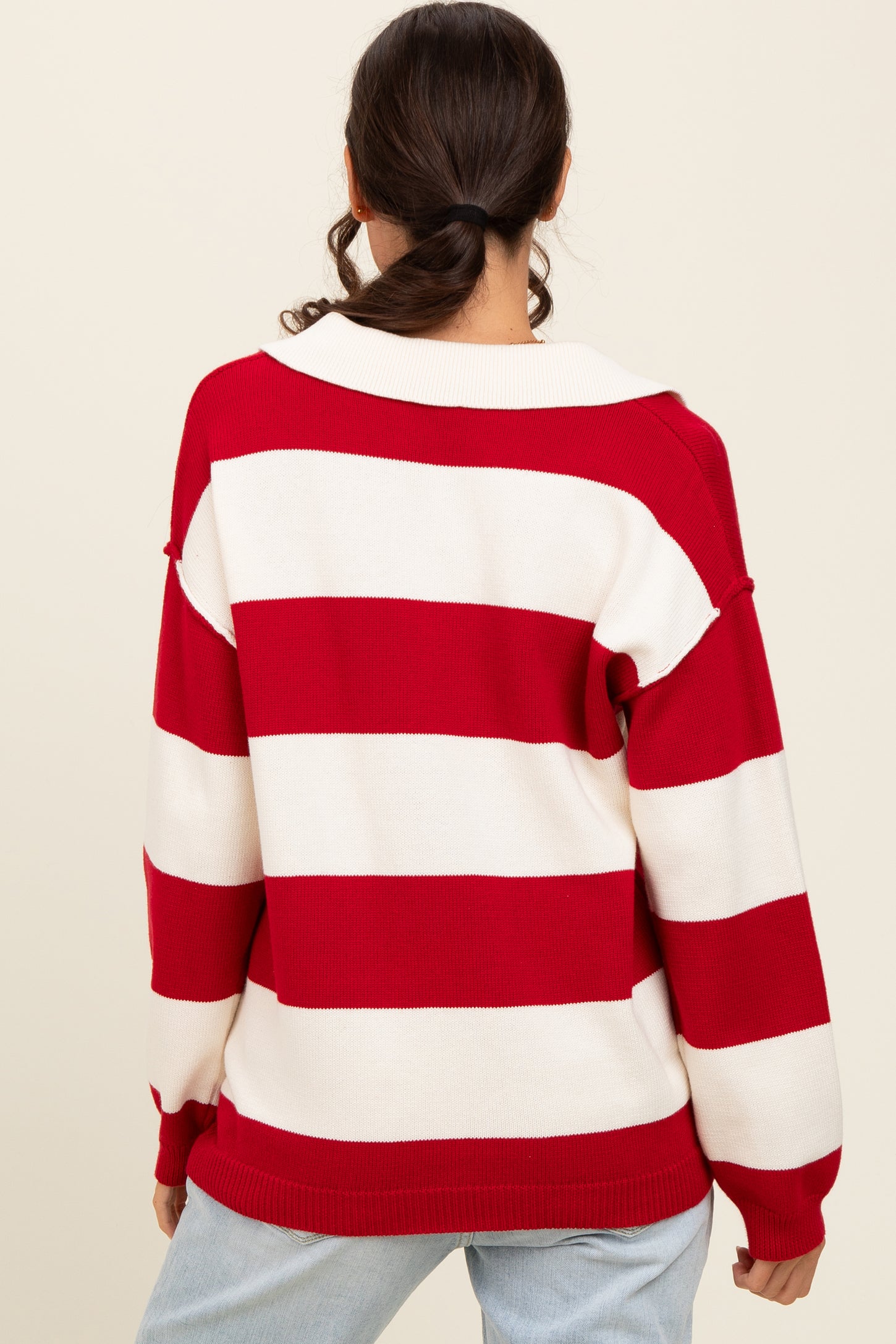 woman wearing a red and white striped oversized sweater, seen from the back with a relaxed fit and wide collar