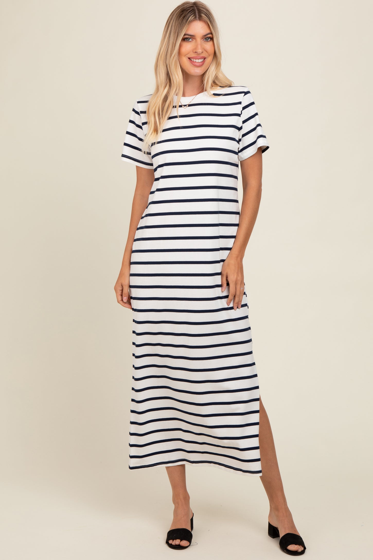 woman wearing a navy and white striped maxi dress with short sleeves and side slits