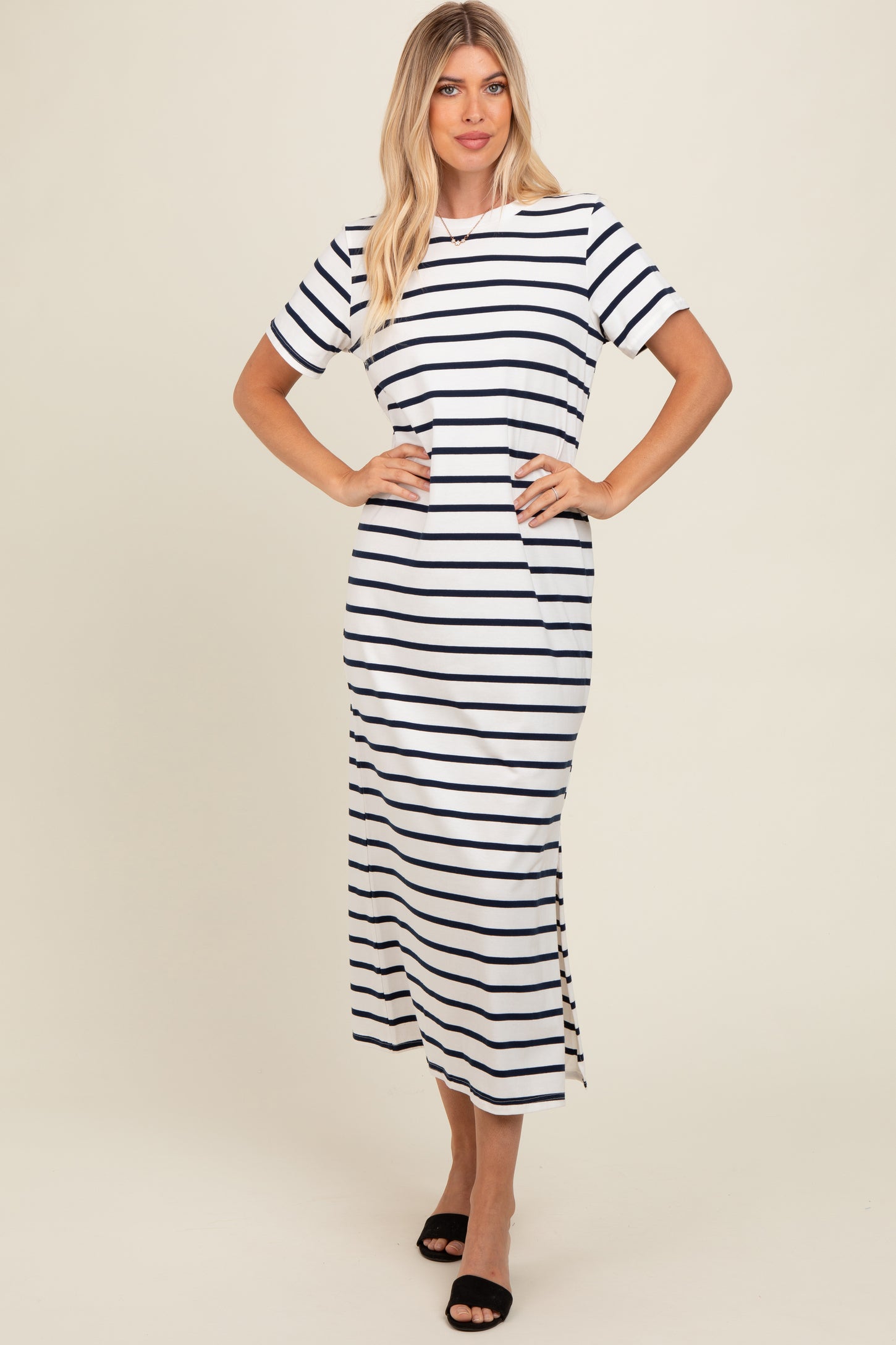 woman wearing a white and navy striped short sleeve maxi dress with a side slit and a relaxed fit