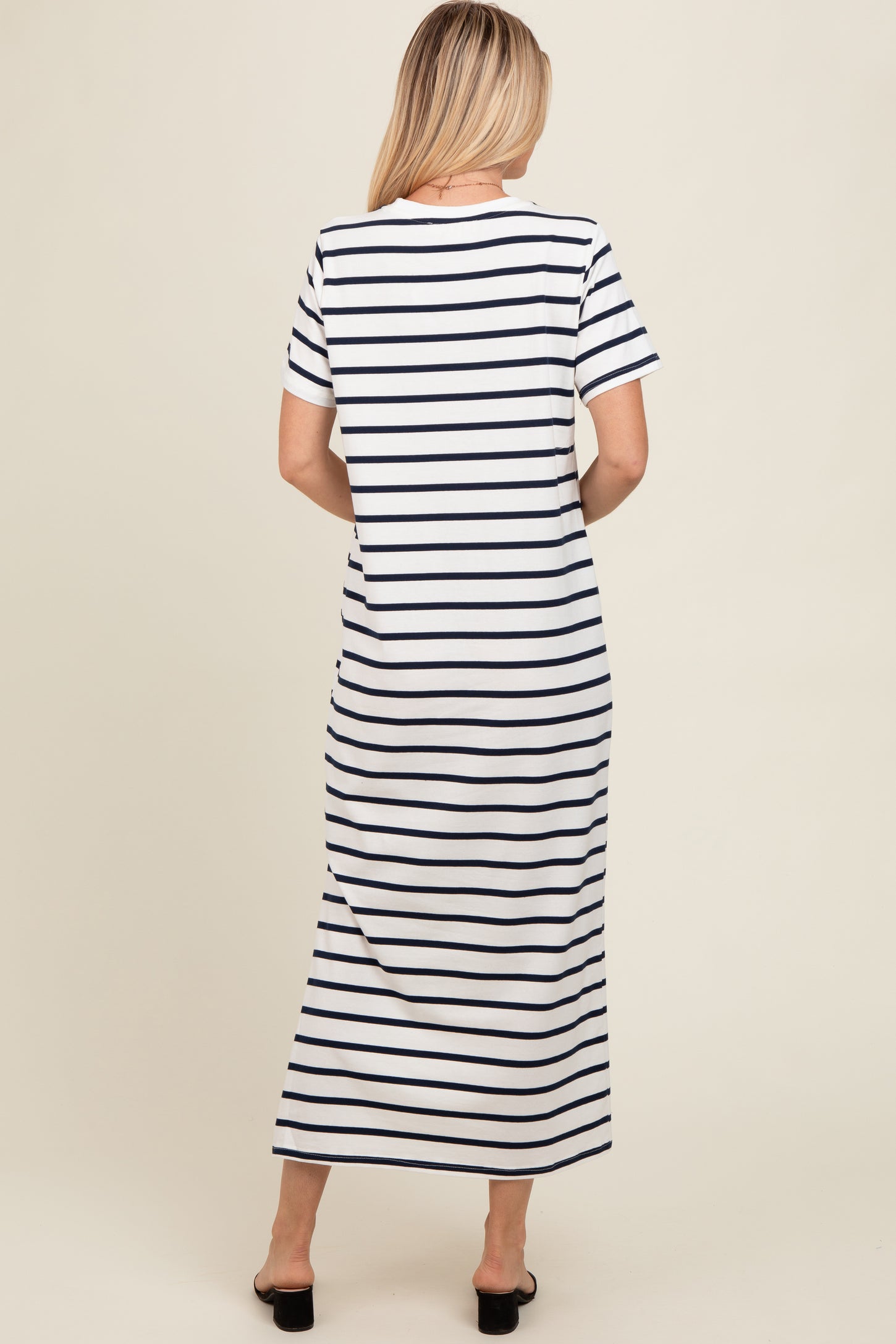 woman wearing a white and navy striped maxi dress with short sleeves, seen from the back