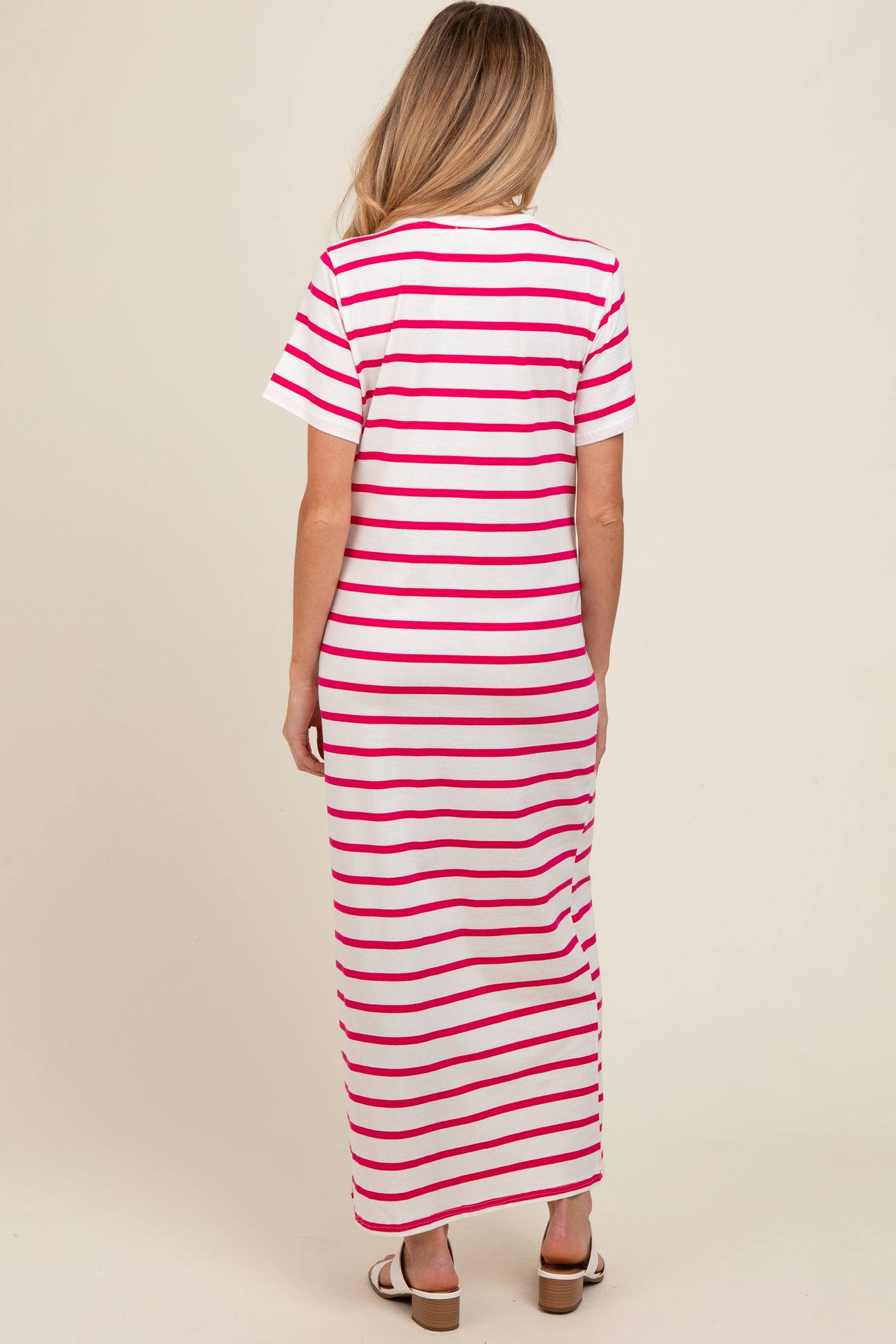 woman wearing a pink and white striped maternity maxi dress with short sleeves, showing the back view