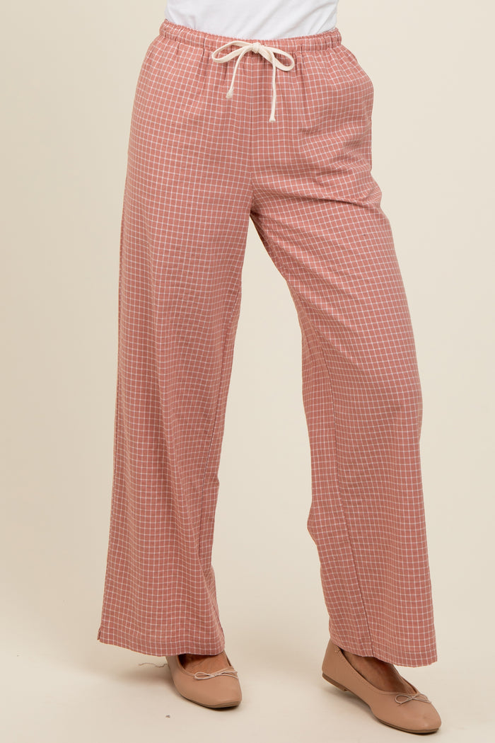 woman wearing rust checked wide-leg pants with a drawstring waistband and brown flats