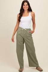 woman wearing a white tank top and green checkered wide-leg pants with a drawstring waist