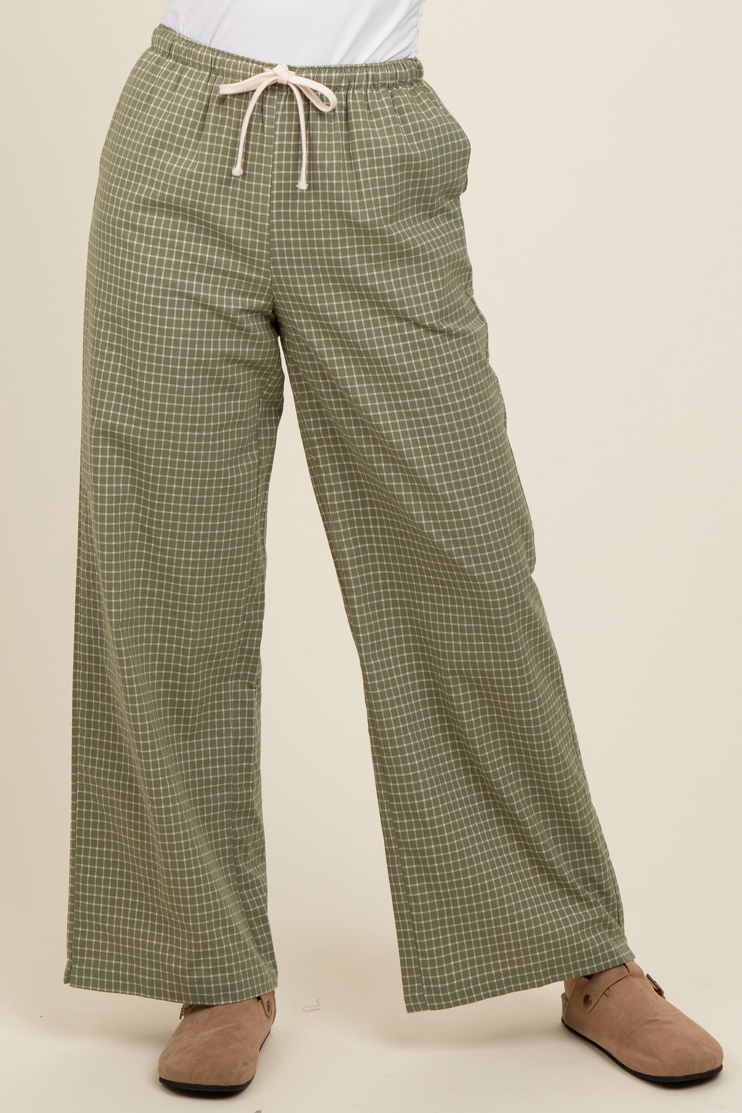 woman wearing green checkered wide-leg pants with drawstring waist and beige slip-on shoes