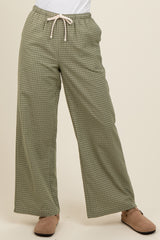 woman wearing green checkered wide-leg pants with drawstring waist and beige slip-on shoes