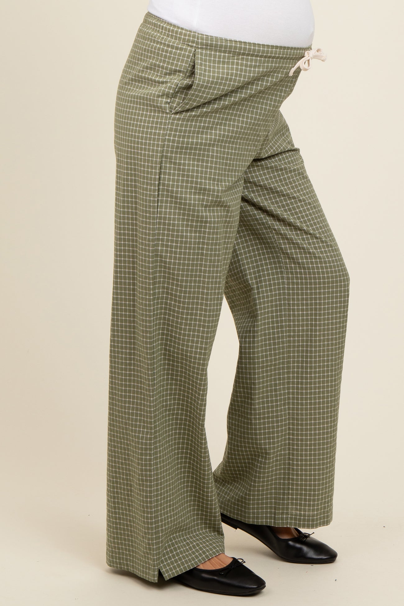 woman wearing olive green checkered maternity wide-leg pants with a drawstring waistband and side pockets