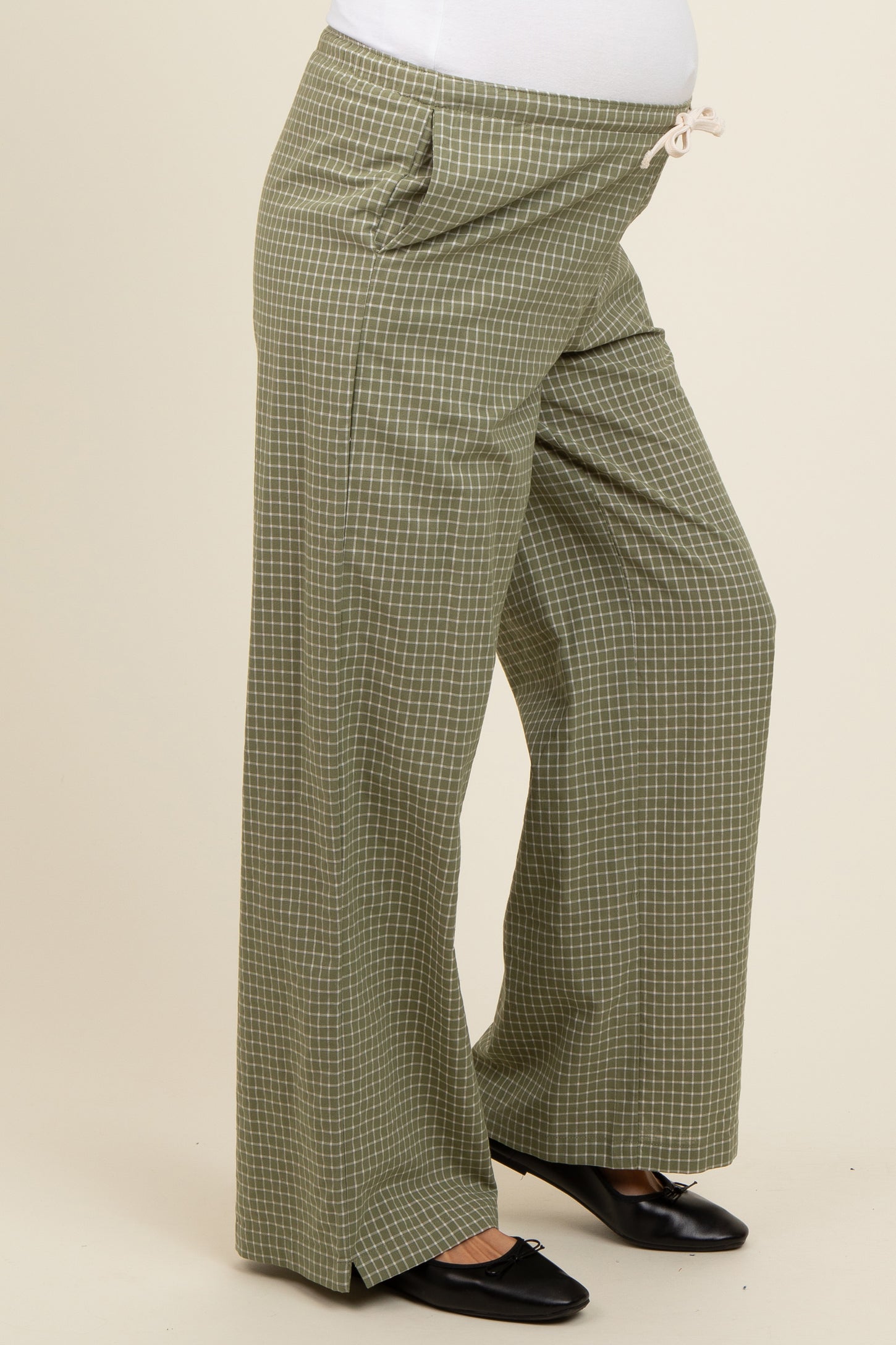 woman wearing olive green checkered maternity wide-leg pants with a drawstring waistband and side pockets
