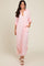 woman wearing a pink and white striped long button-up shirt dress with rolled sleeves and side pockets