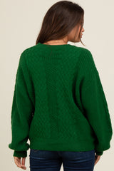 woman wearing a green cable knit maternity sweater with a relaxed fit, view of the back
