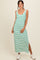 woman wearing a green and white striped maxi dress with a side slit and casual white sneakers