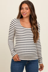 woman wearing a striped black and white long sleeve maternity top with a scoop neckline and smiling at the camera
