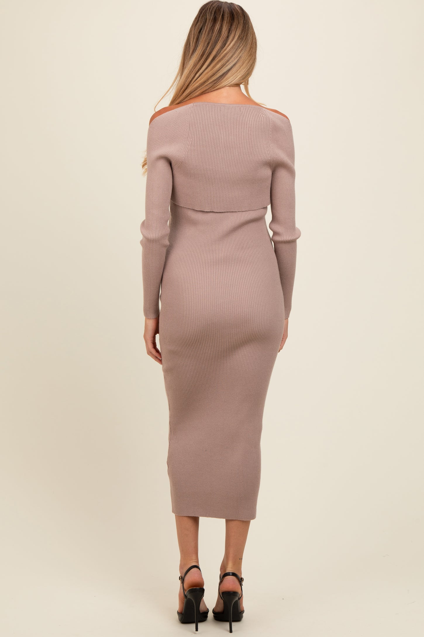 woman wearing a light mauve off-shoulder ribbed maternity dress, showing a fitted silhouette and long sleeves