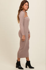 woman wearing a form-fitting ribbed midi dress in light brown and ankle boots, posed side profile against a neutral background