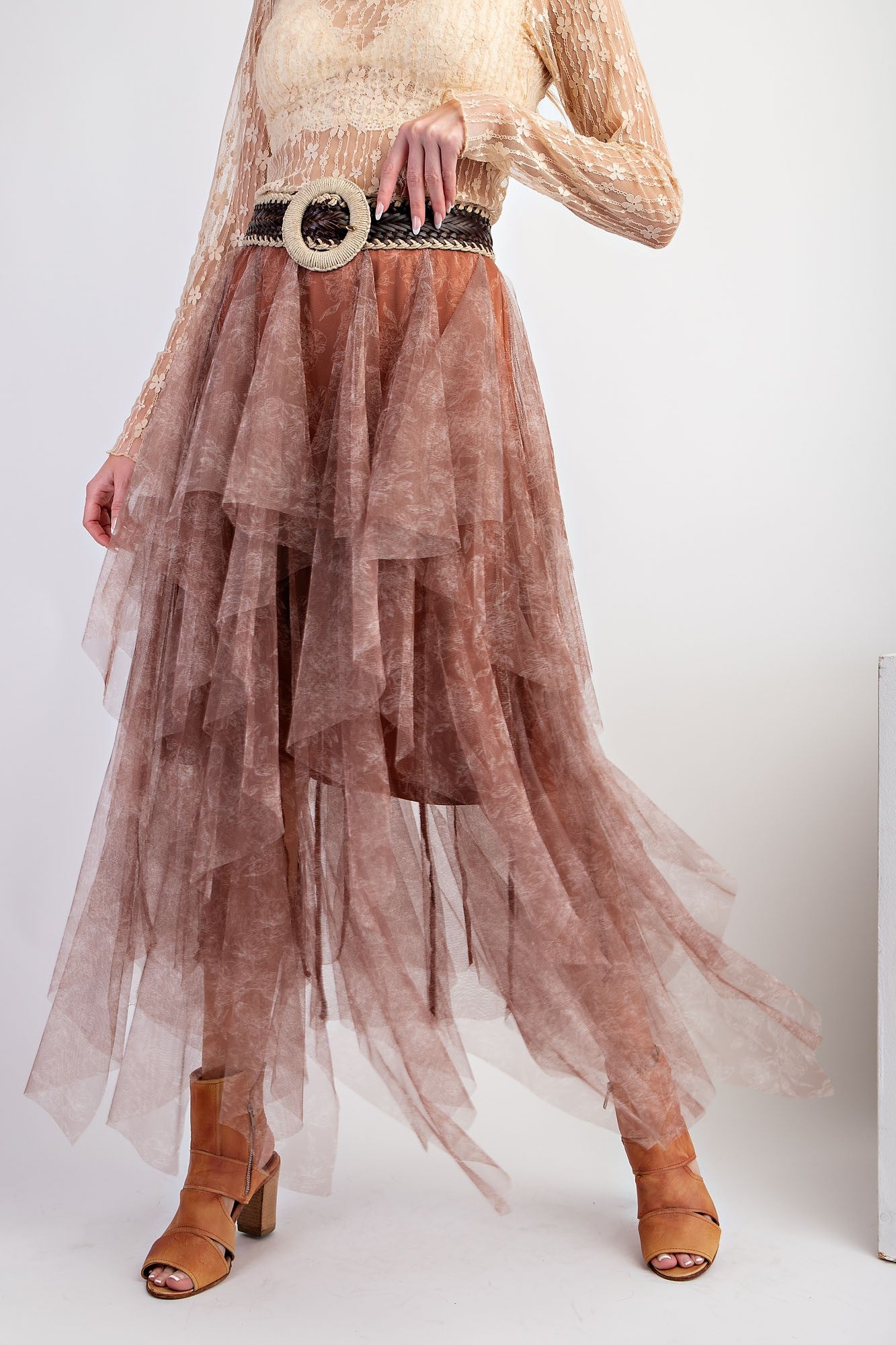 woman wearing a flowy brown layered tulle skirt with a wide belt and tan heeled sandals