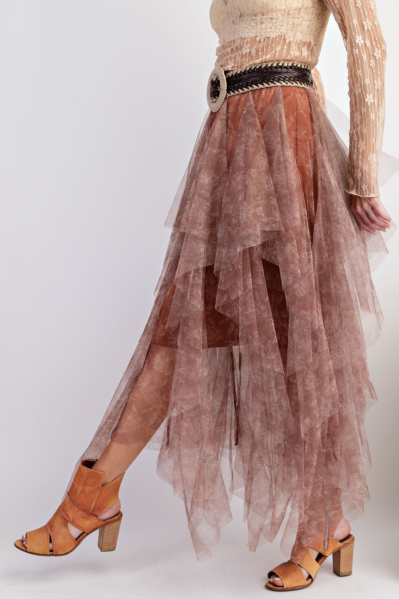 woman wearing a sheer brown layered maxi skirt with a black belt and strappy tan heeled sandals