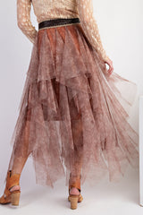 woman wearing a brown layered sheer maxi skirt with ruffles and a decorative belt, back view