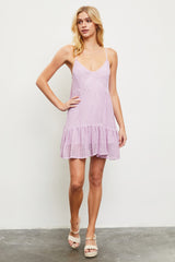 woman wearing a lilac spaghetti strap sundress with a tiered ruffle hem and a relaxed fit