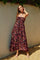 woman wearing a strapless maxi dress with a vibrant multicolor leaf pattern and a fitted bodice