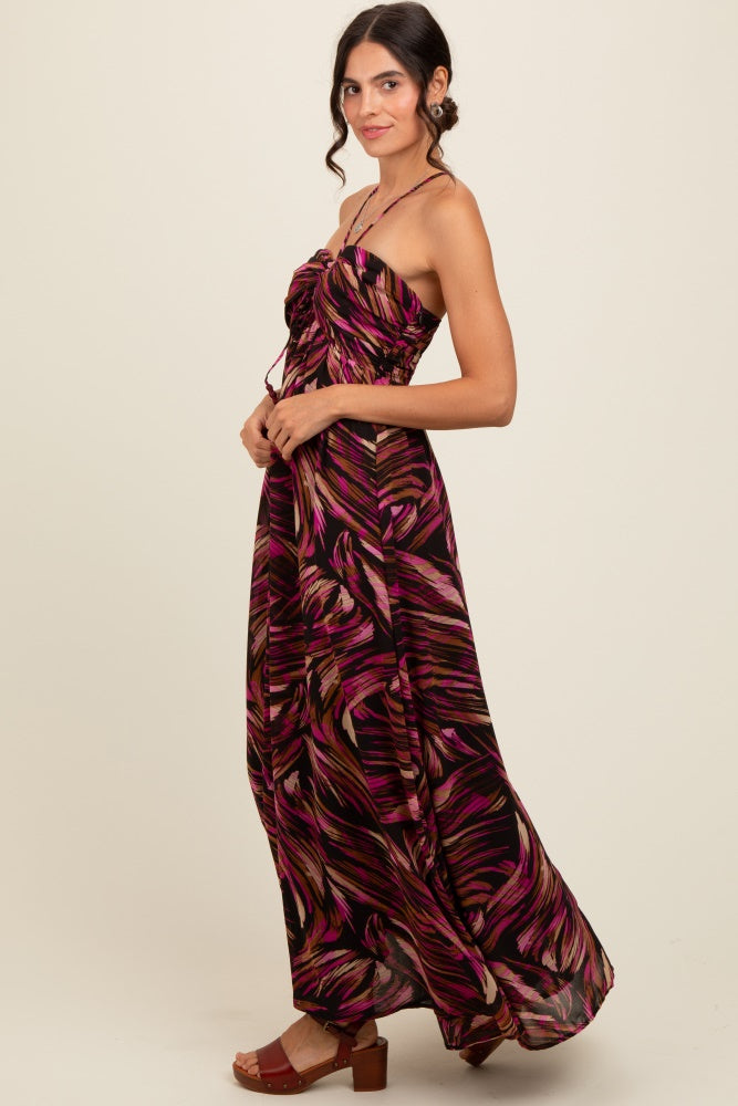 woman wearing a black and pink patterned maxi dress with a strapless design and flowy silhouette
