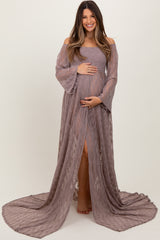 woman wearing a mauve off-the-shoulder lace maternity gown with bell sleeves and a thigh-high slit, holding her baby bump