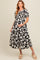 woman wearing a black and white floral maternity dress with a smocked bodice and a baby bump visible