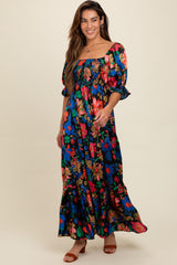woman wearing a long floral maxi dress with puff sleeves and a square neckline, standing against a light background