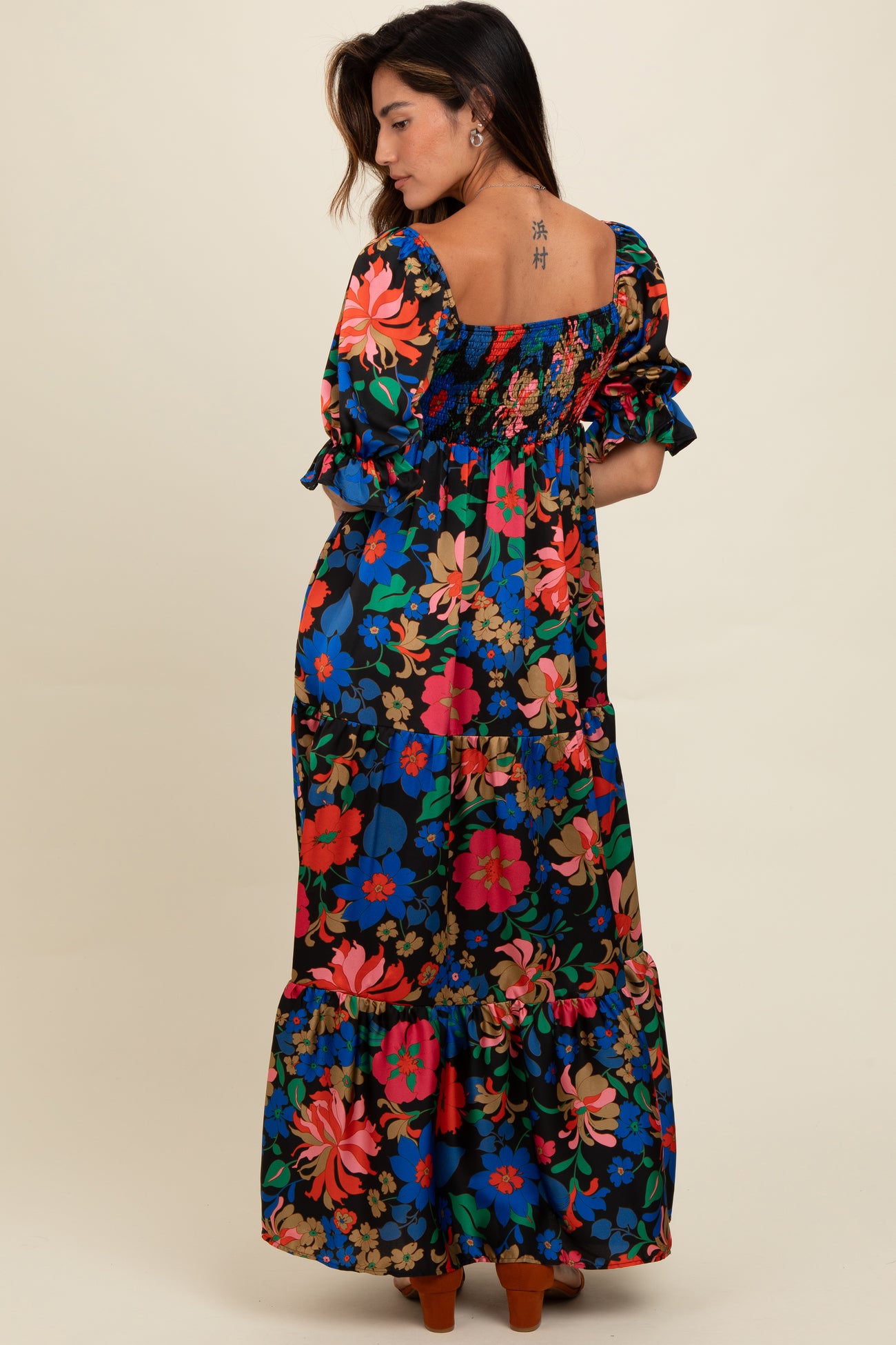 woman wearing a colorful floral maxi dress with puff sleeves and a smocked back design