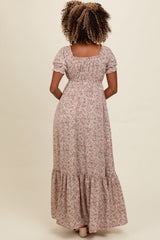woman wearing a floral maxi dress with short puff sleeves and a tiered hem, viewed from the back