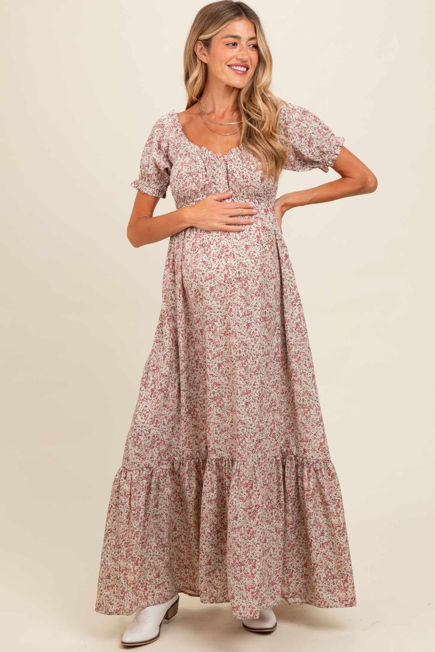 woman wearing a floral maternity maxi dress and holding her baby bump