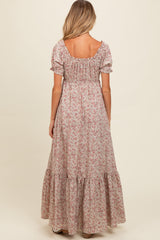 woman wearing a floral long maternity maxi dress with puff sleeves and a tiered hem, showing the back view