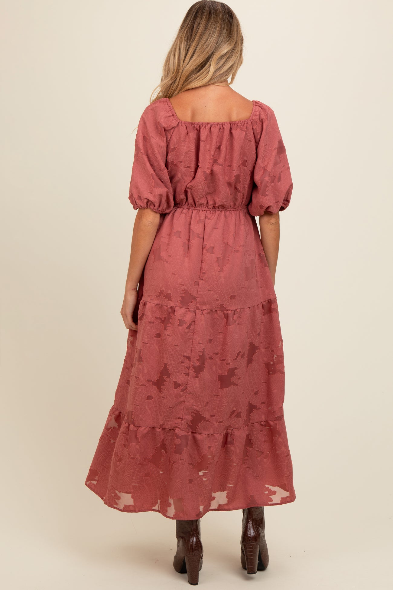 woman wearing a dusty rose maternity maxi dress with puff sleeves and tiered skirt, shown from the back