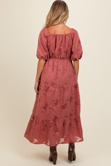 woman wearing a dusty rose maternity maxi dress with puff sleeves and tiered skirt, shown from the back