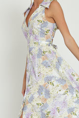woman wearing a sleeveless floral print dress with a collared neckline and a flowing skirt