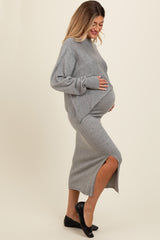 woman wearing a gray maternity sweater dress, side view with a visible baby bump and a thigh-high slit