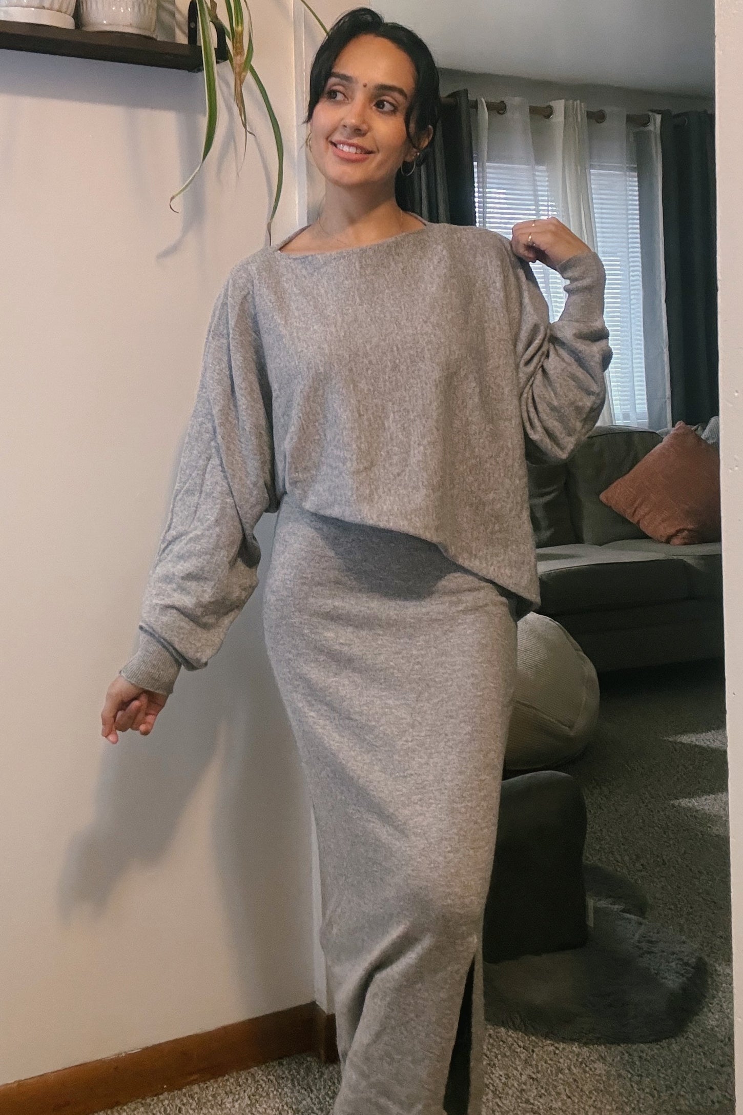 woman wearing a gray long sleeve crop top and matching maxi skirt with a side slit